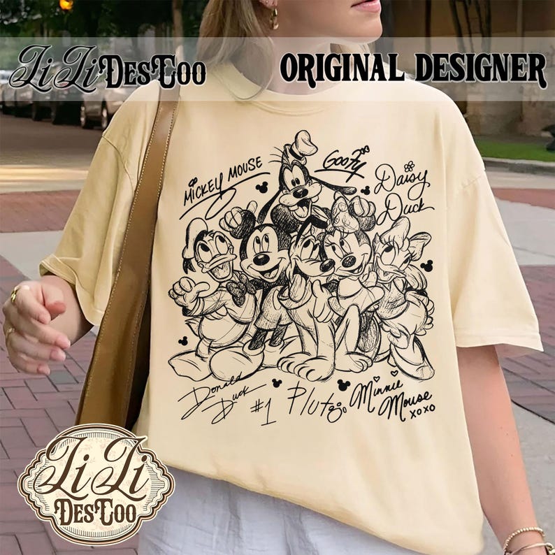 May include: Cream-colored t-shirt featuring a black and white illustration of Mickey Mouse, Minnie Mouse, Donald Duck, Daisy Duck, Goofy, and Pluto. The shirt has the text "Mickey Mouse" and character names. The words "Original Designer" are also visible.