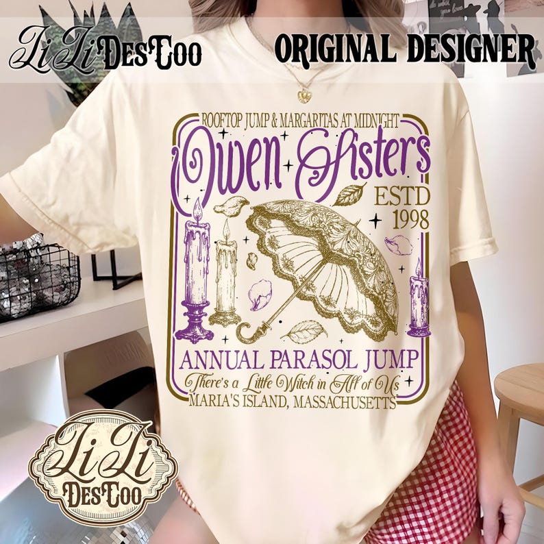May include: A cream-colored t-shirt featuring a graphic print with purple and gold text that reads Owen Sisters, Rooftop Jump & Margaritas at Midnight, Estd 1998, Annual Parasol Jump, There's a Little Witch in All of Us, Maria's Island, Massachusetts.