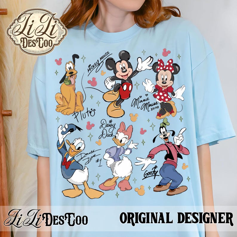 Puede incluir: Camiseta azul claro con ilustraciones de Mickey Mouse, Minnie Mouse, Pluto, Donald Duck, Daisy Duck y Goofy. La camiseta tiene el texto "Mickey Mouse", "Minnie Mouse", "Pluto", "Daisy Duck", "Donald Duck" y "Goofy". La camiseta tambi&eacute;n tiene el texto "Original Designer".