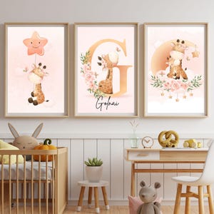 Pu&ograve; includere: Tre stampe artistiche incorniciate per la cameretta con adorabili illustrazioni di giraffe. Una giraffa tiene in mano un palloncino a forma di stella, un'altra &egrave; in una ghirlanda floreale con il nome "Golnai", e la terza &egrave; su una nuvola.