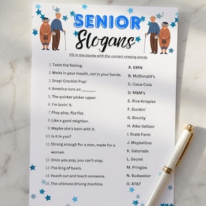 May include: A white paper game sheet titled Senior Slogans with blue star decorations and illustrations of elderly people. The sheet features a numbered list of fifteen slogans and a lettered list of fifteen brand names to match, with a white pen nearby.