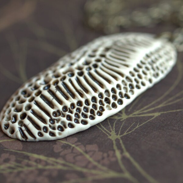 Skin once shed.  A rustic porcelain pendant with scaled texture.