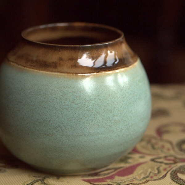 Small, round, wide mouthed vase in turquoise and caramel brown.