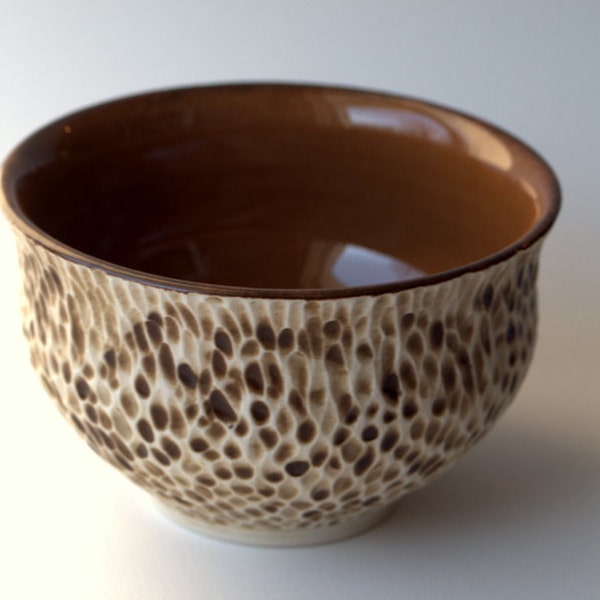 A rustic, textured porcelain bowl with mustard brown interior.