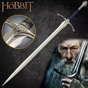 May include: A silver sword with a blue handle and a silver pommel with the inscription "Glamdring" in black lettering. The sword is held by a person with a long white beard.