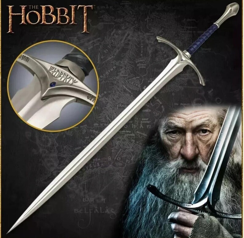 May include: A silver sword with a blue handle and a silver pommel with the inscription "Glamdring" in black lettering. The sword is held by a person with a long white beard.