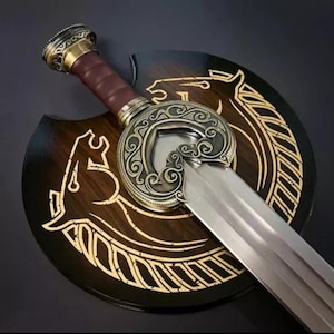 May include: A decorative sword with a gold-colored hilt and a silver blade. The sword is mounted on a wooden plaque with a gold-colored design of a horse and a circle.