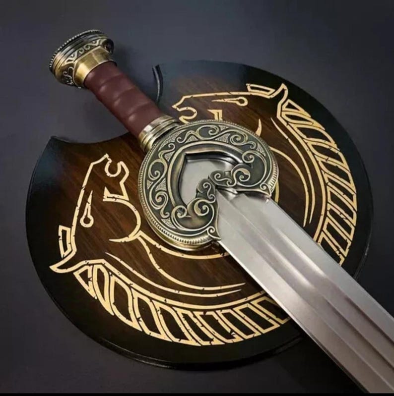 May include: A decorative sword with a gold-colored hilt and a silver blade. The sword is mounted on a wooden plaque with a gold-colored design of a horse and a circle.