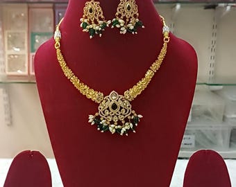 Set composto da collana Rajwadi Hasli placcata in oro con pietre Kundan e orecchini girocollo tradizionali.
