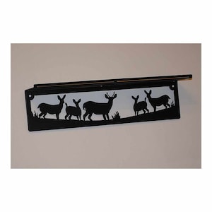 May include: Black metal shelf with a silhouette of a family of deer. The shelf is mounted on a white wall.