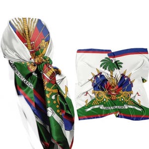 May include: Two silk scarves featuring the Haitian coat of arms. One scarf is knotted, displaying the colors of the Haitian flag: red, blue, green, and white. The other scarf is unfolded, showing the emblem with the text "L'UNION FAIT LA FORCE."