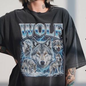 90s bootleg style collage of howling wolves with full moon, blue lightning background and silver chrome WOLF typography on dark wash fabric.