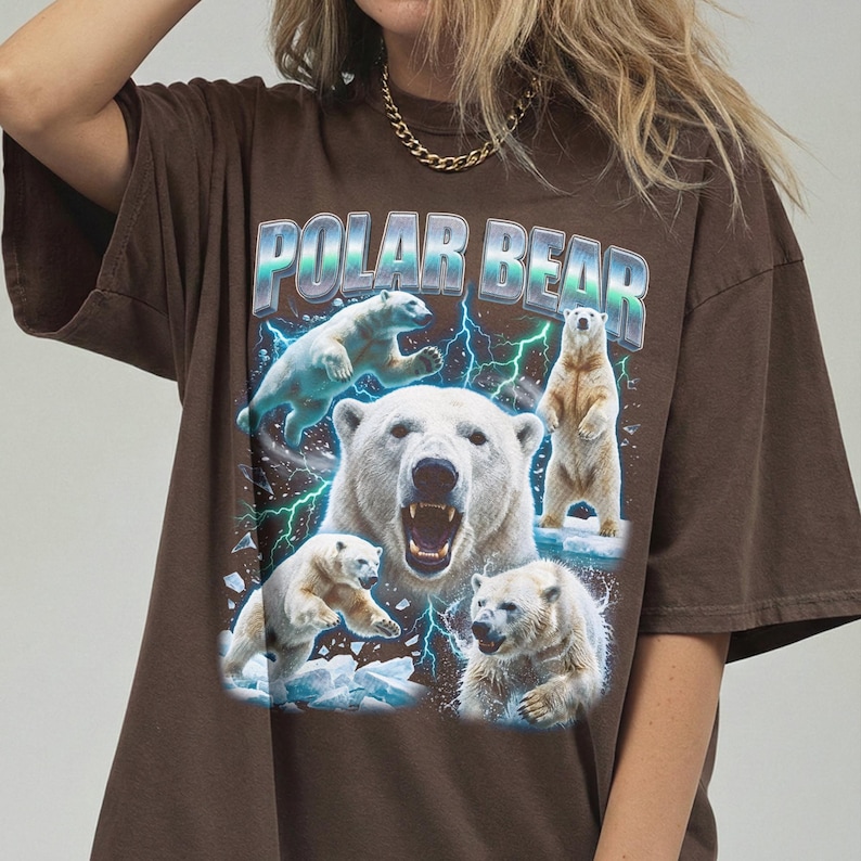 May include: Brown t-shirt featuring a graphic of polar bears with the text "POLAR BEAR" in a blue and silver design. The image shows several polar bears in various poses, with a background of blue lightning.
