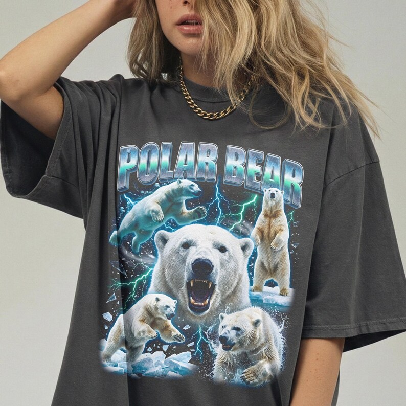 May include: Dark gray t-shirt featuring a graphic of polar bears with the text "POLAR BEAR". The design includes multiple polar bears in various poses, with lightning bolts and ice. The shirt is a relaxed fit.