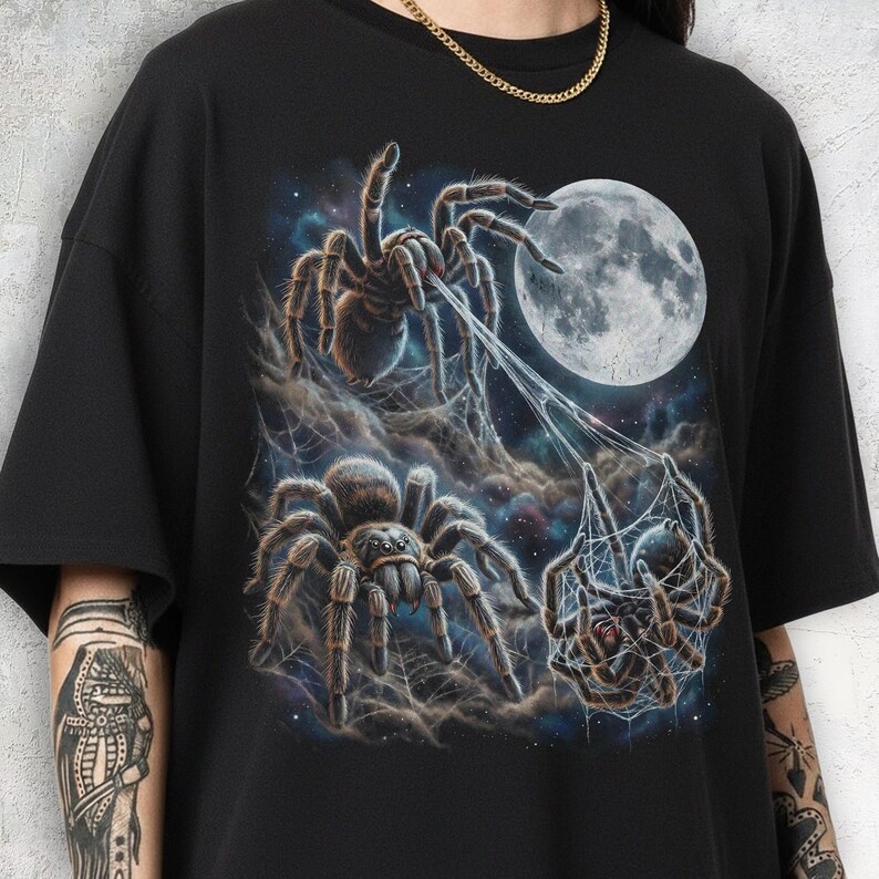 Three realistic tarantula spiders under a large luminous full moon in a starry night sky. One spider at the top spins a web toward the moon. Below, one spider faces forward with funny googly eyes, while the third is entangled in silk webbing. The design features a retro 90s galaxy aesthetic with cosmic nebula clouds.