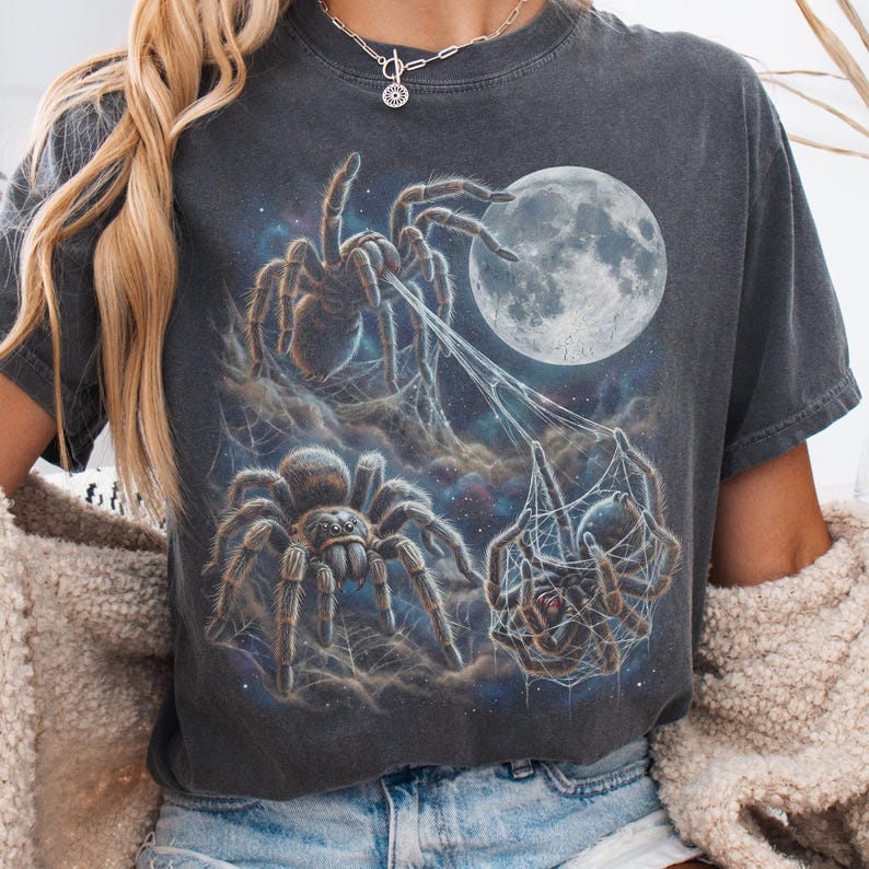 Vintage style three tarantulas moon graphic printed on dark washed t-shirt, hairy spider galaxy design spinning web.