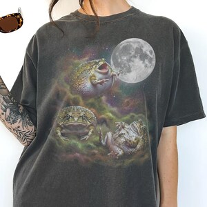 Vintage style three desert rain frogs moon graphic printed on dark washed t-shirt, cute angry rock screaming galaxy design with funny belly up pose.