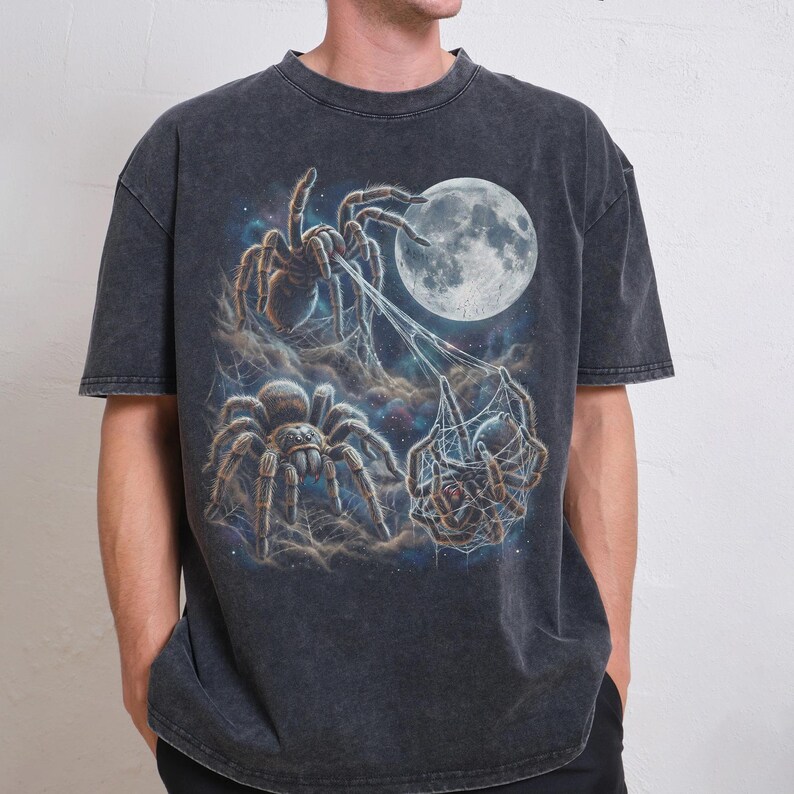 Vintage style three tarantulas moon graphic printed on dark washed t-shirt, hairy spider galaxy design spinning web.