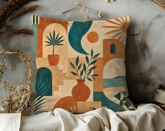 May include: Square decorative pillow with a geometric design featuring terracotta, teal, and beige tones. The design includes arches, stairs, and potted plants, evoking a Mediterranean or desert landscape. The pillow is likely made of a soft fabric.