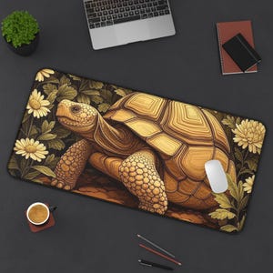 May include: A rectangular desk mat featuring a detailed illustration of a tortoise. The tortoise is depicted in shades of brown and tan, surrounded by yellow flowers and green foliage. A white mouse rests on the mat.