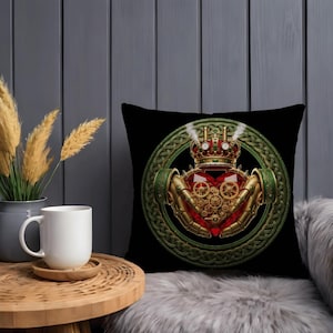 May include: Black throw pillow featuring a steampunk Claddagh design. The design includes a red heart, a crown, and hands holding the heart, all with gears and metallic accents. The pillow has a green Celtic knot border.