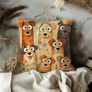 May include: Decorative square pillow featuring a whimsical illustration of several cartoon dogs with large eyes and floppy ears. The dogs are in shades of brown, tan, and gray, set against a patterned background. The pillow is likely made of soft fabric.