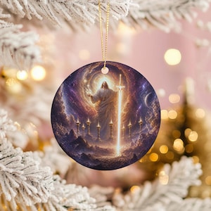 May include: Round Christmas ornament featuring a celestial image of a figure in white robes holding a sword, surrounded by a glowing light and candles. The background is a swirling galaxy of purple and gold.