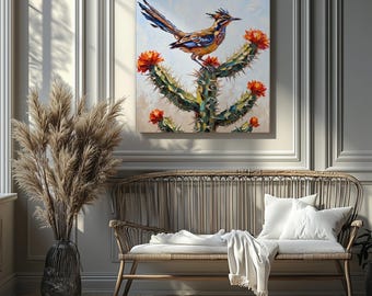 May include: A square canvas painting depicts a roadrunner bird perched on a cactus with orange flowers. The bird has brown, blue, and orange feathers. The cactus is green with thorns. The painting is displayed above a wicker bench with white pillows and a blanket.