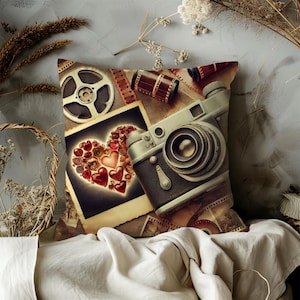 May include: Decorative throw pillow featuring a vintage camera, film reels, and a heart-shaped design made of hearts. The pillow has a neutral color palette with sepia tones, creating a nostalgic aesthetic. Perfect for photography enthusiasts.