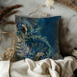 May include: A square throw pillow featuring a deep navy blue background with a botanical print of green pine branches, blue juniper berries, and delicate golden fern fronds. The design displays a rich, dark color palette with intricate natural details.