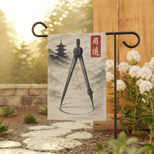 May include: A garden flag featuring a watercolor design with a compass, mathematical equations, and a Japanese pagoda. The flag has a red rectangle with Japanese characters. The background shows a mountain landscape.