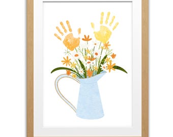May include: A framed art print featuring a light blue pitcher filled with a bouquet of flowers and two handprints. The flowers are white, orange, and yellow, with green leaves. The frame is a light brown color.
