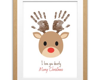 May include: Framed print featuring a reindeer design with handprint antlers, a brown face, and a red nose. The text "I love you dearly Merry Christmas" is written in red script below the reindeer. The print is in a wooden frame.