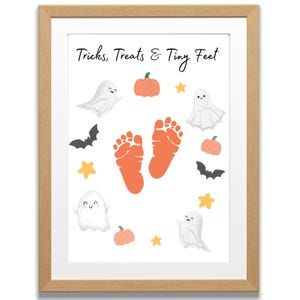 May include: A framed Halloween-themed print with the text "Tricks, Treats & Tiny Feet." The artwork features orange footprints, ghosts, pumpkins, bats, and stars in a playful design, perfect for seasonal decor.