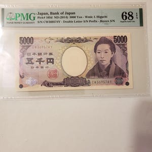 以下が含まれることがあります： 日本銀行の5000円日本銀行券、ND（2014年）、I. 樋口の透かし入り。この紙幣は68 EPQと評価され、シリアル番号はCW369574Yです。この紙幣には日本語のテキストが記載されています。