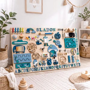 May include: A large wooden busy board featuring the name SLADON, an alphabet from A to Z, and numbers 0 to 10. The board includes various interactive elements like a xylophone, gears, a robot, a clock, a mirror, and latches in shades of blue.