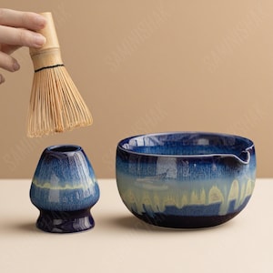以下が含まれることがあります： 青と白のセラミックボウル、お揃いのセラミック泡立て器ホルダー、竹製の泡立て器を備えた抹茶ティーセット。 ボウルには注ぎ口があります。 このセットは、伝統的な抹茶を準備するために設計されています。