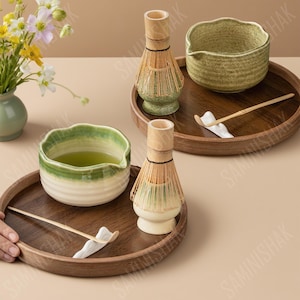 以下が含まれることがあります： 木製のトレイに抹茶セットが2つ。各トレイには、セラミックボウル、竹の泡立て器、スプーンがセットされています。ボウルには抹茶が入っています。花が入った小さな花瓶も含まれています。