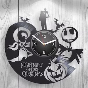 Puede incluir: Un reloj de pared negro hecho de un disco de vinilo con siluetas de personajes de The Nightmare Before Christmas, incluyendo a Jack Skellington, Sally y Zero. La esfera es circular con manecillas blancas y el texto Nightmare Before Christmas.