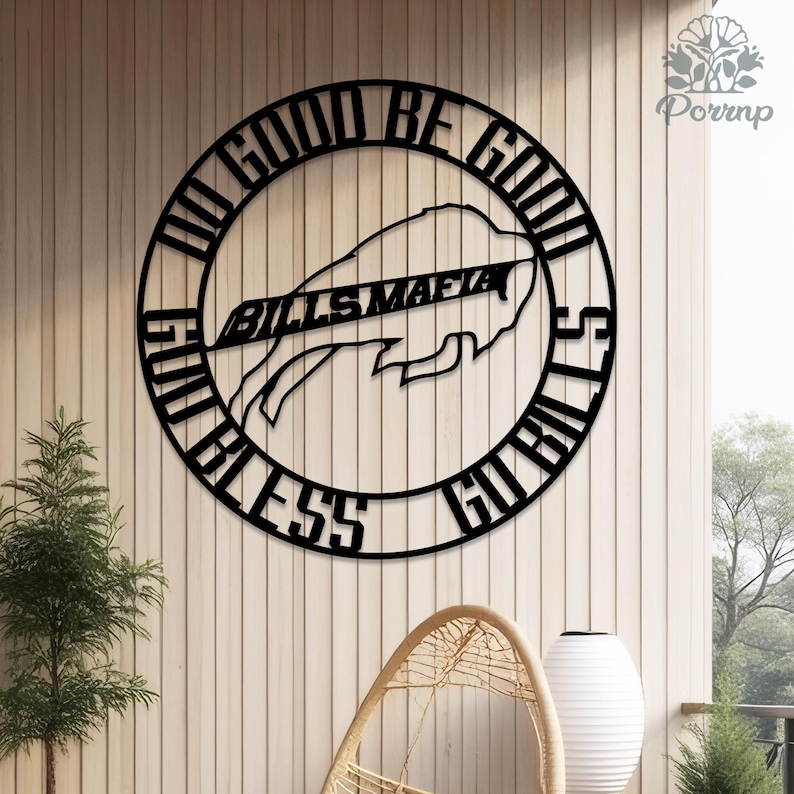 May include: A black metal wall art piece featuring the text "DO GOOD BE GOOD" and "GO BILLS" in a circular design. The words "BILLS MAFIA" are centered, with a buffalo logo. The art is mounted on a light-colored wooden wall.