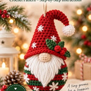 Peut inclure: Un modèle de crochet pour une boule de Noël gnome avec un bonnet rouge à flocons blancs brodés, une barbe en laine blanche, un nez beige et une base verte à flocons blancs. Le texte indique Christmas Gnome Ball Crochet Pattern.