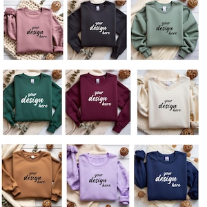 Peut inclure: Plusieurs sweatshirts à col rond de différentes couleurs, dont rose poudré, noir, vert sauge, vert forêt, bordeaux, crème, marron, lavande et bleu marine. Chaque sweat-shirt porte l'inscription "your design here" en écriture cursive.