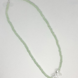 Hellgrüne Perlenkette mit Charm aus weißem Band