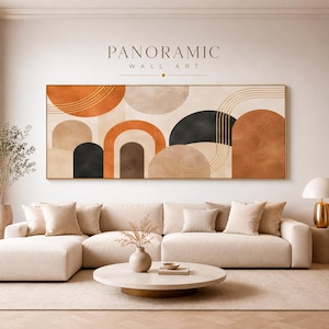 Könnte beinhalten: Ein panoramisches Wandbild mit abstrakten geometrischen Formen in den Farben gebranntes Orange, Beige, Schwarz und Creme. Die Komposition umfasst Bogenformen und geschwungene Linien, präsentiert über einem beigen Ecksofa und einem runden Couchtisch.