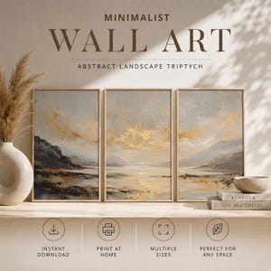 Könnte beinhalten: Ein Triptychon aus abstrakter Landschaftswandkunst in hellen Holzrahmen mit einer Farbpalette aus Grau, Beige und Gold. Das Kunstwerk zeigt einen ruhigen Horizont mit texturierten Wolken und Wasser. Text: MINIMALIST WALL ART.
