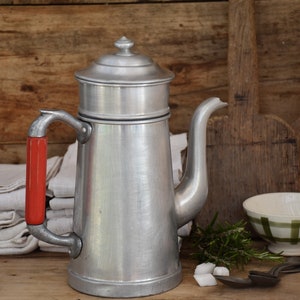 Ancienne cafetière en aluminium avec une poignée rouge, Cuisine
