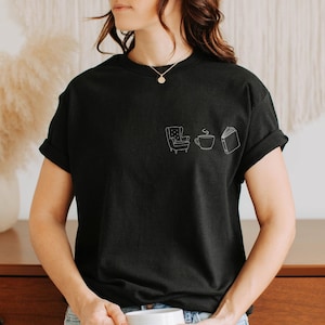 Cozy Reading Shirt – Minimalist T-shirt with armchair, tea and book, tranquil book lover look, gift for bookworms, coziness Schwarz