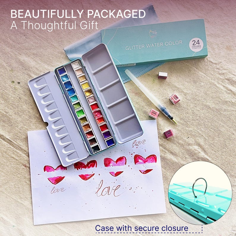 May include: A teal metal watercolor paint set with 24 colors, a brush, and watercolor paper with red heart designs and the word "love". The text "BEAUTIFULLY PACKAGED A Thoughtful Gift" is at the top.