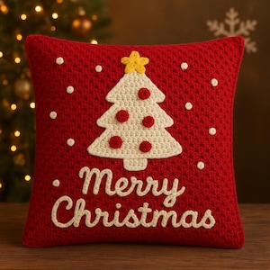 May include: A red crochet cushion featuring a white Christmas tree design with red baubles and a yellow star. The words "Merry Christmas" are embroidered in white. White polka dots are scattered across the cushion.