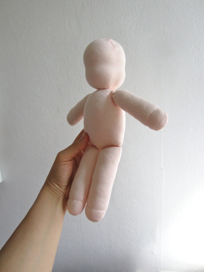 May include: A pink fabric doll with a simple design. The doll has a head, arms, and legs, and is made of a soft, plush fabric.